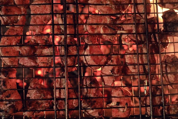 Trozos de carne picada en una parrilla para cocinar barbacoa en charco —  Fotos de Stock