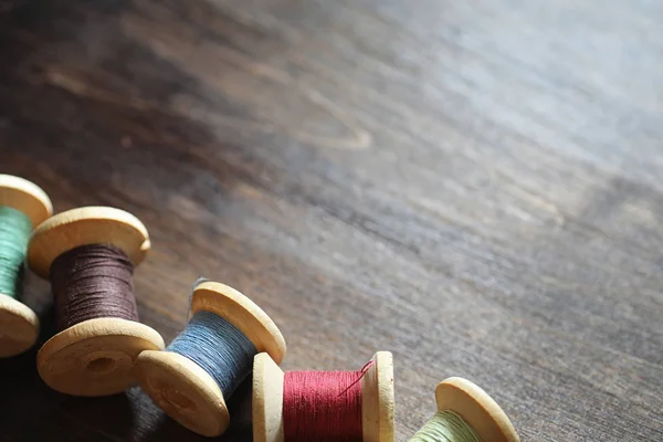 Filo da cucire su uno sfondo di legno. Set di fili su bobine — Foto Stock