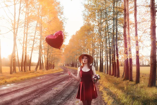 Una ragazza con un cappello mentre passeggia nel parco. Una ragazza con un cesto a piedi — Foto Stock