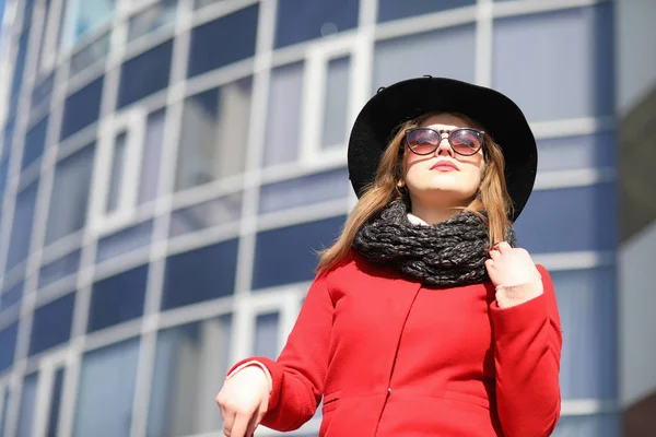 Chica bonita en un paseo en abrigo rojo en la ciudad — Foto de Stock