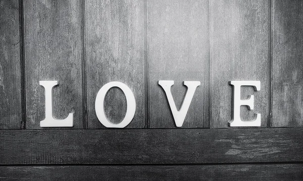 Word love made up of white wooden letters on a wooden background — Stock Photo, Image