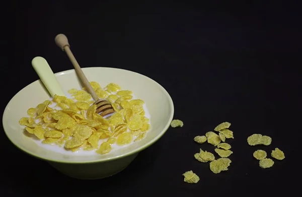 Cornflakes in een bord. Ontbijt van vlokken met honing en mil — Stockfoto