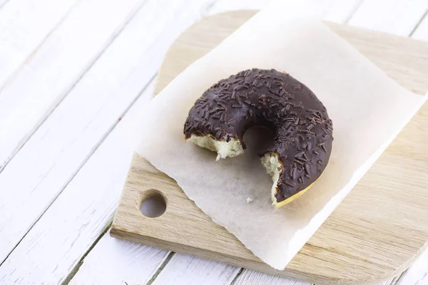 Donut de chocolate em um fundo branco de madeira — Fotografia de Stock