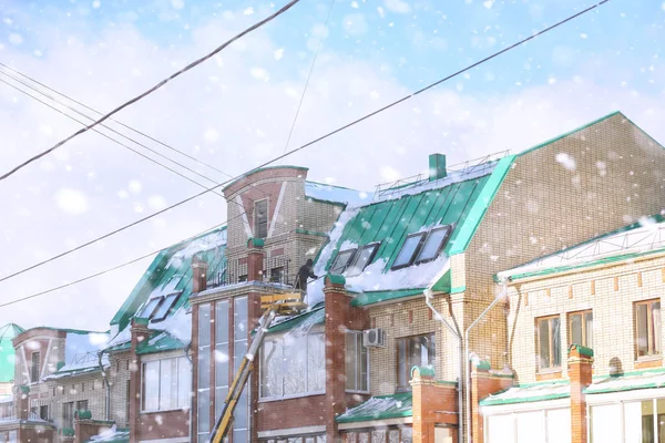 The cleaning service cleans the snow from the roof of the house. — Stock Photo, Image