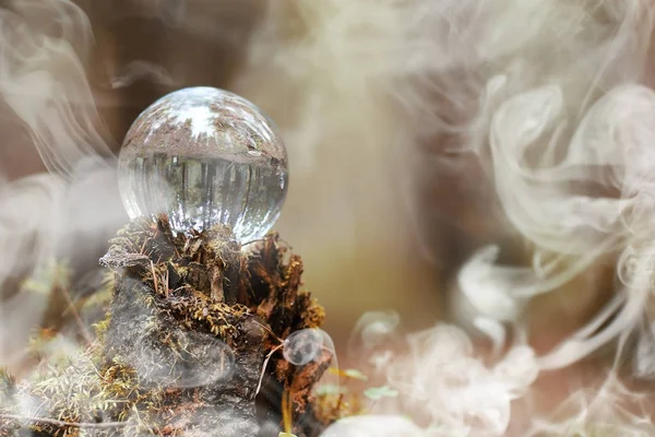 A crystal ball in the smoke. A magical accessory in the woods on — Stock Photo, Image