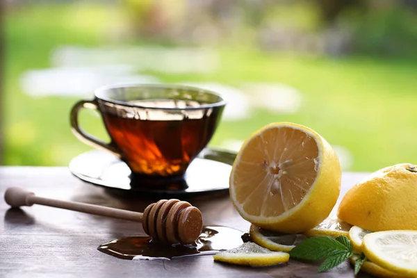 Frischer Honig mit einer Tasse Schwarztee — Stockfoto