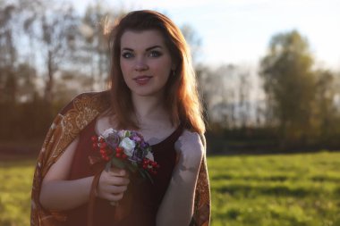 Parkta bir yürüyüş üzerinde şapkalı bir kız. Bir kızla bir sepet yürüyüş