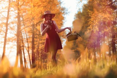 Parkta bir yürüyüş üzerinde şapkalı bir kız. Bir kızla bir sepet yürüyüş