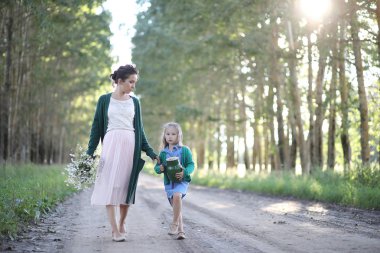 Anne ve kızı yolda yürüyor.