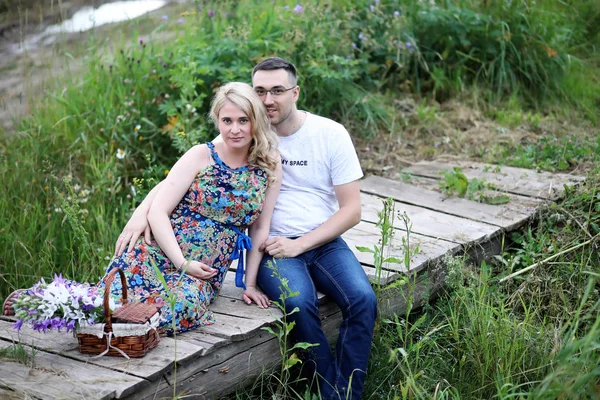 Fille enceinte avec gros ventre et jeune homme en plein air — Photo