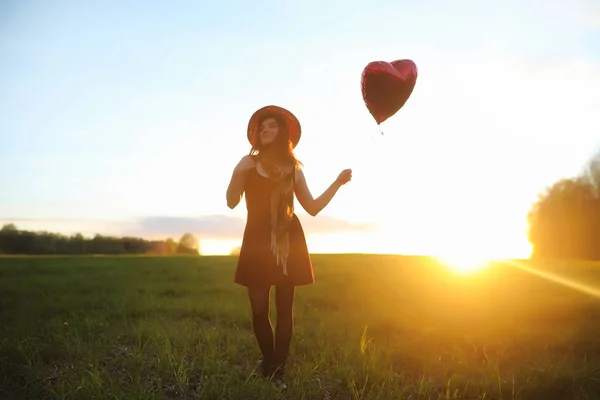 Una ragazza con un cappello mentre passeggia nel parco. Una ragazza con un cesto a piedi — Foto Stock