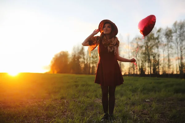 Una ragazza con un cappello mentre passeggia nel parco. Una ragazza con un cesto a piedi — Foto Stock