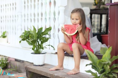 Sevimli sarışın kız karpuz açık bir dilim yiyor