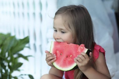 Sevimli sarışın kız karpuz açık bir dilim yiyor