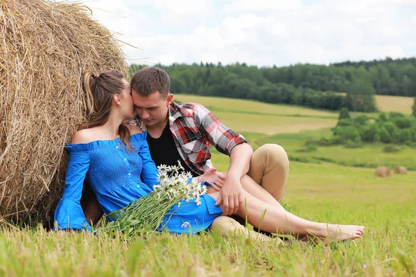 Couple amoureux dans un champ au coucher du soleil — Photo