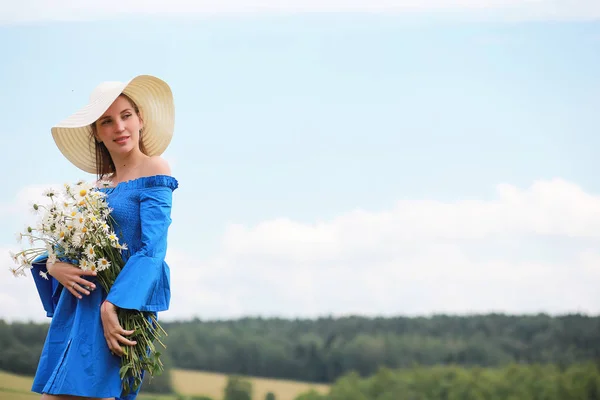 Young cute girl in a hat in a field at sunset Royalty Free Stock Images