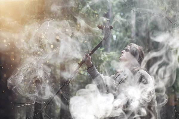 Um homem numa batina passa um ritual numa floresta escura. — Fotografia de Stock
