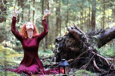 Kızıl saçlı cadı bir ritüel bir kristal top ile tutar