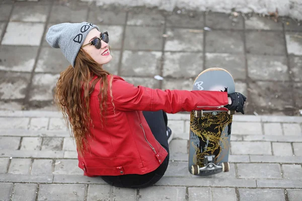 Una giovane hipster sta cavalcando uno skateboard. Ragazze amiche f — Foto Stock