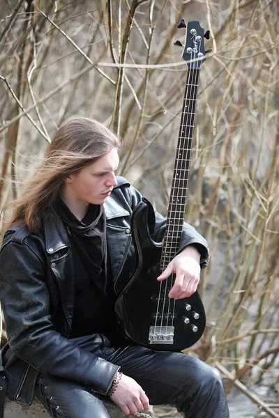 Guitarrista de rock nos degraus. Um músico com uma guitarra baixo em um — Fotografia de Stock