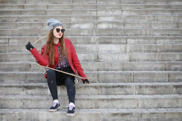 Una giovane hipster sta cavalcando uno skateboard. Ragazze amiche f — Foto Stock