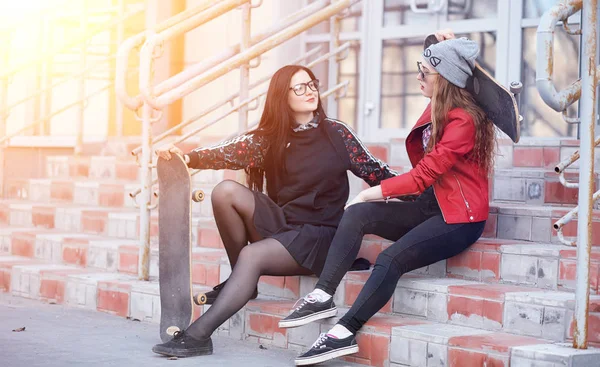 Uma jovem hipster está montando um skate. Meninas namoradas f — Fotografia de Stock