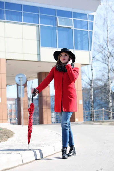 Empresária bonito em um casaco vermelho contra um fundo de vidro — Fotografia de Stock