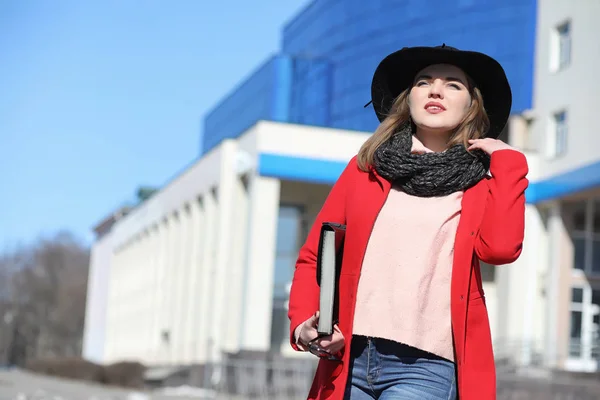 Ładna dziewczyna na spacerze w czerwony płaszcz w mieście — Zdjęcie stockowe