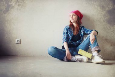 Kız dairede tamirat yapıyor. Eve yeni bir daireye taşınıyor. İşçi onarım, sıvalı yapar ve duvar matkaplar.