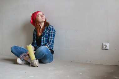 Kız dairede tamirat yapıyor. Eve yeni bir daireye taşınıyor. İşçi onarım, sıvalı yapar ve duvar matkaplar.