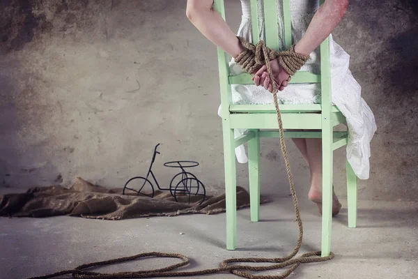 Young girl tied up on the floor. The abducted girl. The victim o — Stock Photo, Image