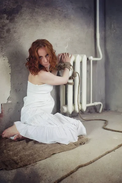 Young girl tied up on the floor. The abducted girl. The victim o — Stock Photo, Image