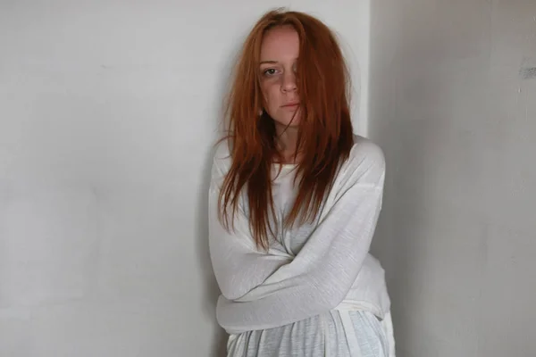 Una chica con el pelo rojo en camisa. Violencia doméstica y sacrificio. Chica con una psique enferma . — Foto de Stock