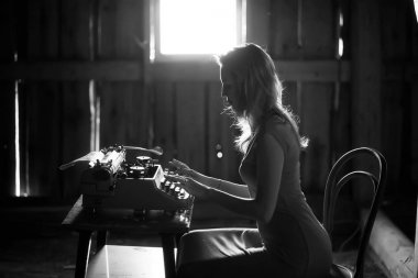 Bir kız üzerinde eski bir daktilo yazdırır