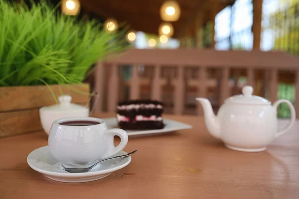 Wasserkocher mit Getränk und Dessert in einem Straßencafé. Tee im Korb — Stockfoto