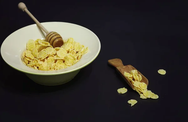 Copos de maíz en un plato. Desayuno de hojuelas con miel y mil — Foto de Stock