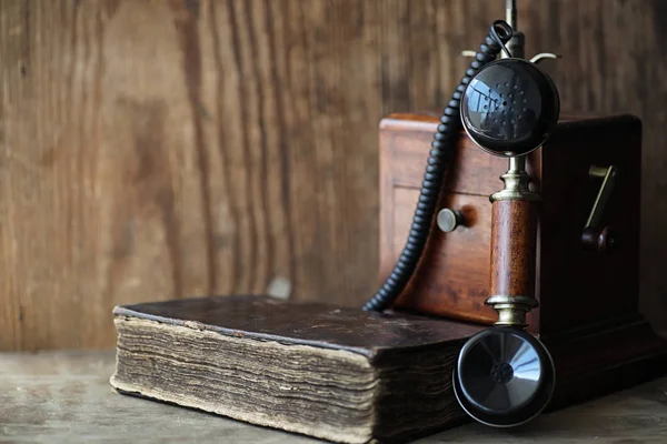 Telefone velho e livro retro em uma madeira — Fotografia de Stock