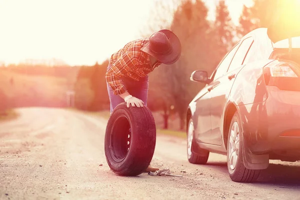 Man sitter på vägen av bilen — Stockfoto