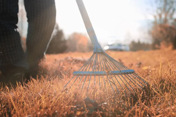 Mann mit Rechen im herbstlichen Gras — Stockfoto