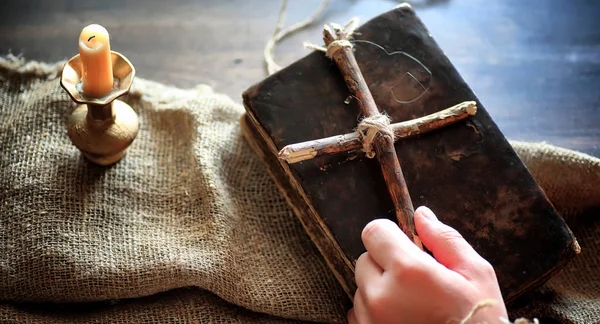 O carte veche religioasă pe o masă de lemn. O cruce religioasă legată de spirit — Fotografie, imagine de stoc