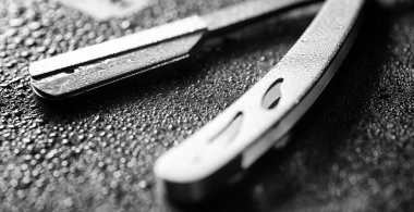 Tehlikeli bir ustura ve masanın üzerinde metal bir bıçak. Mens tıraş 