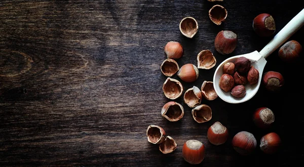 Noix sur une table en bois.Noisettes dans les coquilles et décortiquées. Un malheur. — Photo