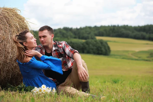 Couple amoureux dans un champ au coucher du soleil — Photo