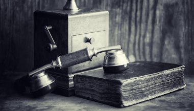 Eski telefon ve retro kitap masanın üzerinde. Geçmişte telefon 