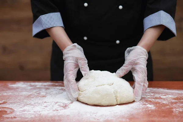 De kok maakt meel voor het bakken op tafel — Stockfoto