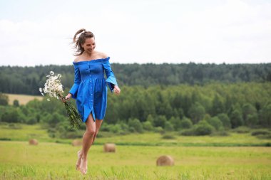 Genç tatlı kız bir alanda gün batımında koşmak