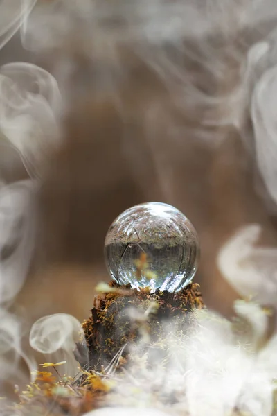 Uma bola de cristal no fumo. Um acessório mágico na floresta em — Fotografia de Stock