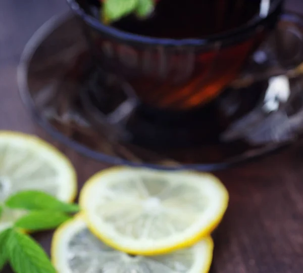 Tea with lemon and mint in nature. A cup of hot mint tea with le — Stock Photo, Image