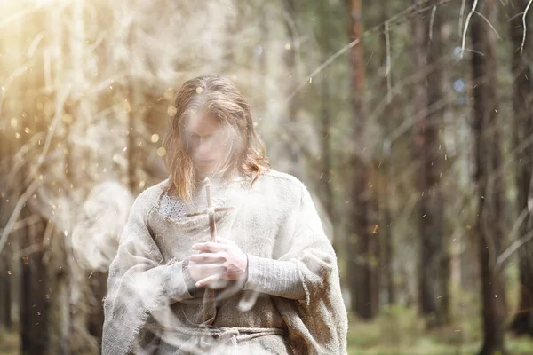 En man i en Kaftan tillbringar en ritual i en mörk skog — Stockfoto