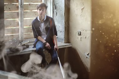 Beyzbol sopalı bir genç. 